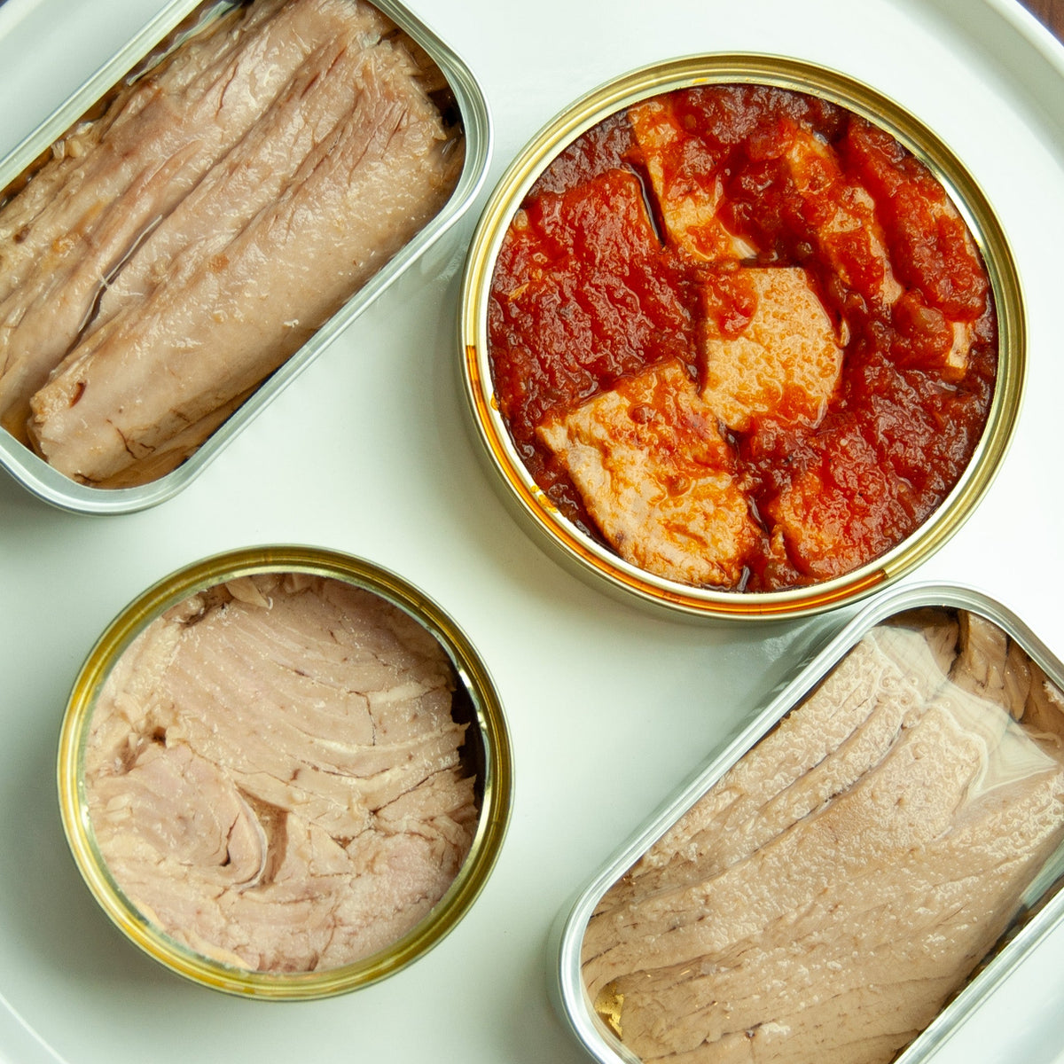 spread of open tuna tins including alalunga tuna with tomato sauce