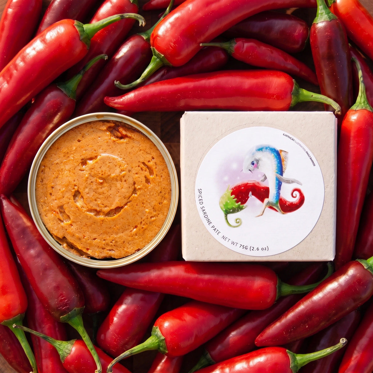 Jose Gourmet Spiced Sardine Pate laying on a bed of red peppers.