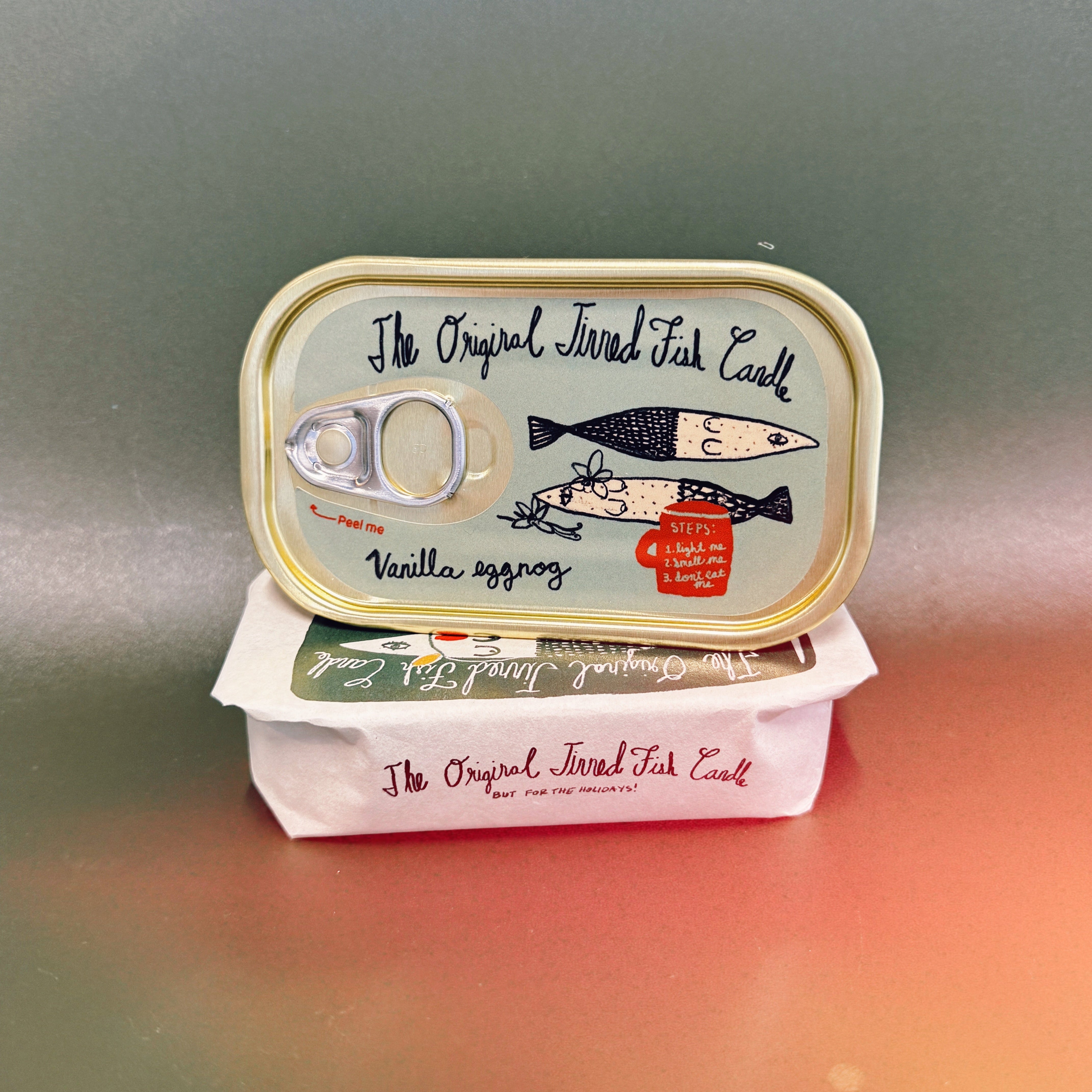 Two tins of 'The Original Tinned Fish Cakes' on a gradient background